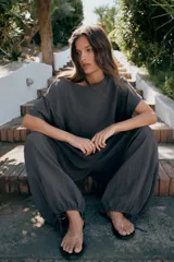Pantalón baggy de tiro medio color rosado, con cintura elástica fruncida tipo nido de abeja y bajos ajustables con cordones.