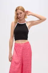 Top cropped de poliamida con diseño color block, presenta un cuerpo negro con bordes en contraste color blanco, cuello a la base y ajuste al cuerpo.