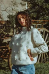 Sweater de lana merino color blanco, tejido a mano con textura tridimensional de flores en punto bodoque, cuello redondo a la base y mangas largas.