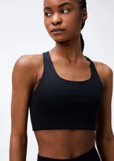 Top deportivo lila de corte cuadrado, con tirantes anchos y espalda deportiva.