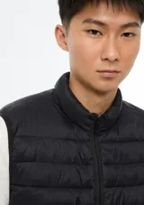 Chaleco puffer negro con cierre frontal, cuello alto y diseño acolchado horizontal.