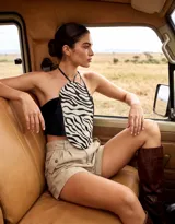 Top halter de cuero con diseño asimétrico 2 en 1, combinando panel negro liso en la espalda y lateral con panel frontal con estampado animal print de cebra.
