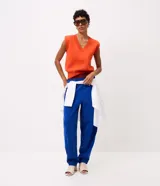 Chaleco de tricot naranja con escote en V profundo, hombreras internas y terminaciones acanaladas en cuello, sisas y bajo.