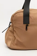 Bolso de nylon en color verde militar, con diseño deportivo, asas de mano resistentes, cierre superior y bolsillos laterales con frunce ajustable mediante cordón elástico.