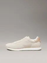 Zapatillas Calvin Klein de perfil bajo, confeccionadas en una combinación de ante, piel y lona en tonos beige. Presentan un diseño minimalista con suela de caucho y logo de la marca estampado en el lateral.
