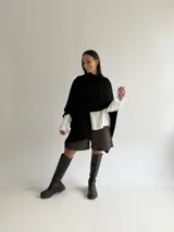 Ruana de tejido de punto trenzado en color crudo, con diseño abierto, corte holgado y mangas amplias tipo kimono.