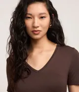 Blusa básica de manga corta con cuello en V, confeccionada en tejido de viscosa con elastano. Presenta un diseño liso y corte ajustado.