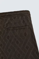 Bermuda de corte regular confeccionada en tejido fluido con textura jacquard geométrica. Presenta cintura elástica con cordón ajustable, bolsillos laterales y bolsillos traseros de vivo.