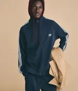 Campera deportiva azul marino Blue Steel de cuello alto, con cierre frontal de cremallera, mangas largas con rayas blancas contrastantes, bolsillos laterales y bordado localizado en el pecho.