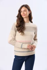 Buzo de tejido de punto con diseño de rayas horizontales en tonos neutros, beige y detalles en rosa y gris. Presenta cuello redondo, mangas largas y terminaciones en rib acanalado en puños y ruedo. Incluye una pequeña etiqueta de cuero sintético en el lateral inferior.