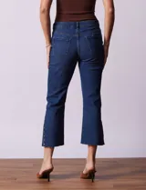 Pantalón jean azul oscuro, tiro alto, corte recto y terminación bootcut. Tiene bolsillos delanteros y traseros, pretina con pasadores, botón y cierre. Aplique de tachas en los laterales.