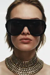 Maxi collar tipo choker de diseño rígido y estructurado, compuesto por múltiples filas de piezas metálicas doradas intercaladas con pequeñas incrustaciones de cristales brillantes.