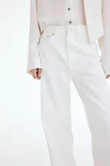 Jean amplio de tiro alto confeccionado en denim rígido color blanco, con diseño de cinco bolsillos y cierre frontal con botón y cremallera.