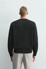 Jersey de punto con corte regular fit, cuello redondo y manga larga. Presenta un diseño de textura acanalada con acabados en rib en puños y bajo.