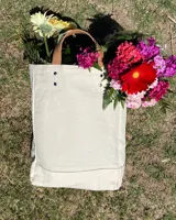 Bolso tote de loneta color crudo con base reforzada y asas cortas de cuero con estampado animal print.