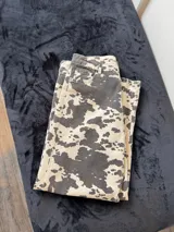 Pantalón largo de tiro bajo con estampado de manchas de vaca en tonos blanco y gris.