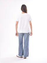 Remera color crudo de corte recto y mangas cortas, con estampado de un pez koi rojo en el pecho. 