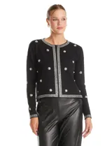 Chaqueta tejida de punto color negro, con cuello redondo y cierre frontal invisible. Presenta un diseño decorado con apliques de strass facetados y perlas en forma de flores y líneas en los bordes.