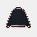 Campera de tejido de punto azul marino, corte oversize, con cierre frontal y cuello polo. Presenta detalles en tejido acanalado de color bordó y blanco en cuello, puños y ruedo. Las mangas tienen franjas decorativas en blanco y bordó. El frente lleva bordado el texto "EMEST UDIOS" en blanco.