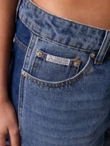 Jeans wide leg de tiro medio con diseño de pierna ancha, lavado azul claro en el frente y franjas laterales en tono azul oscuro contrastante. Confeccionado en algodón.