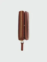 Billetera compacta Marc Jacobs de cuero negro con cierre perimetral y broches dorados. El interior cuenta con múltiples ranuras para tarjetas y compartimento para billetes.
