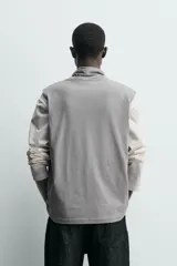 Camiseta sin mangas de corte relajado, confeccionada en algodón ligero, con cuello subido ajustable mediante cordones.