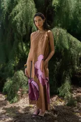 Vestido largo sin mangas de corte holgado, confeccionado en algodón color tostado con estampado floral de gran tamaño en tonos rosados y bordó.