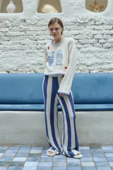 Pantalón de tejido crochet a rayas verticales azules y blancas.