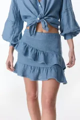 Minifalda azul de lino con dos volados superpuestos, terminación de encaje en los bordes.