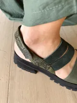 Sandalia de cuero verde con ajuste de velcro y suela track.