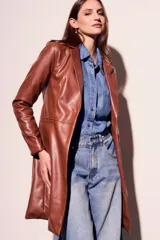 Trench marrón de cuero vegano, corte al cuerpo y largo hasta la rodilla.