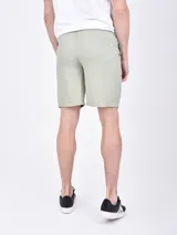 Bermuda de gabardina color beige, con cintura elástica ajustable con cordón, bolsillos laterales y traseros.