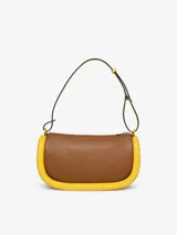 Bolso de hombro JW Anderson modelo Bumper-15, color rosa con ribetes tubulares acolchados en verde oscuro. Tiene correa de hombro ajustable, cierre con cremallera superior y logo estampado en el frente.