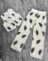 Conjunto blanco con estampado de hojas color borgoña, compuesto por un chaleco con botones y un pantalón de corte recto.