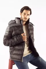 Campera puffer de diseño color block, combinando tonos azul oscuro y gris. Cuenta con capucha desmontable, cierre frontal de cremallera, cuello elevado y bolsillos laterales con cierre de botón.