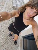 Top tejido negro de algodón con breteles finos y pespuntes blancos.