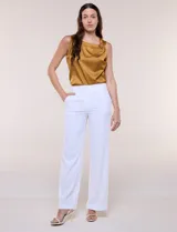 Pantalón sastrero blanco de tiro alto, corte wide leg y pierna ancha con caída fluida. Cuenta con cintura ancha lisa, cierre frontal oculto y bolsillos laterales.