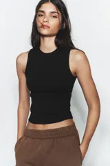 Top musculosa de punto acanalado color blanco, con cuello redondo.