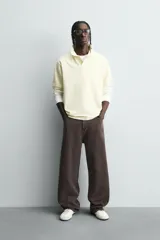 Pantalón de corte baggy fit confeccionado en tejido de algodón con textura y efecto lavado. Presenta diseño de cinco bolsillos, cierre frontal con cremallera y botón.