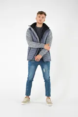 Campera híbrida con cuerpo acolchado en color gris azulado y mangas de felpa gris jaspeado. Cuenta con capucha, cierre frontal y bolsillos con cierres impermeables.