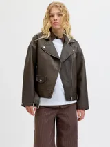 Campera estilo biker de efecto cuero en color marrón desgastado, con cuello solapa, cierre frontal asimétrico, bolsillos laterales con cierre y bolsillo pequeño con solapa y botón a presión. Presenta un corte holgado y diseño versátil.