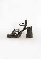 Sandalias de tacón alto y plataforma, color negro, con capellada de tiras cruzadas y cierre de hebilla en el tobillo. Cuentan con textura grabada en todo su diseño.
