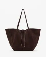 Bolso tipo shopper de piel de serraje, con dos asas de hombro, cierre de botón magnético y cierre de lazo. Cuenta con un bolsillo interior con cremallera y forro de algodón.