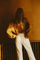 Jean de tiro alto con corte acampanado desde la rodilla. Presenta bolsillos tipo parche en la parte frontal y cierre con botón metálico.