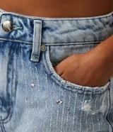 Short de jean de tiro alto, color celeste, con bolsillos y detalles de strass y estrellas.
