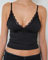 Top negro de breteles finos con escote en V decorado con puntilla de encaje. Confeccionado en tela lisa con ajuste al cuerpo.
