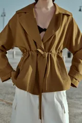 Chaqueta estilo trench corta color azul marino confeccionada con lino. Cuenta con cuello solapa, manga larga con trabilla, bolsillos delanteros de vivo y cierre frontal con lazada ajustable en la cintura.