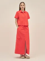 Falda larga color coral, estilo cargo, con cintura ajustable, tajo en el frente y bolsillos laterales.