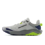Championes New Balance Nitrel V6 de hombre, color gris con detalles en azul marino y verde flúor, diseñados para trail running y senderismo. Cuenta con capellada de malla transpirable, tecnología DynaSoft en la entresuela y suela AT Tread.