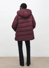 Campera acolchada de corte recto y diseño puffer, color bordó. Cuenta con capucha, cuello alto, cierre frontal de cremallera doble y dos bolsillos laterales con cierre. Presenta mangas largas con puños elásticos y acabado repelente al agua.